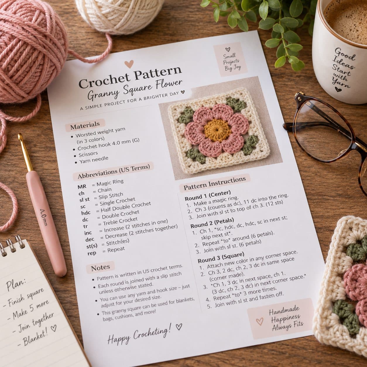 Printed crochet pattern sheet for a granny square flower with a crochet hook, yarn and glasses on a desk